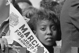 https://upload.wikimedia.org/wikipedia/commons/0/05/A_Young_Woman_Holds_a_Banner_at_the_Civil_Rights_March_on_Washington%2C_D.C.%2C_on_August_28%2C_1963.jpg
